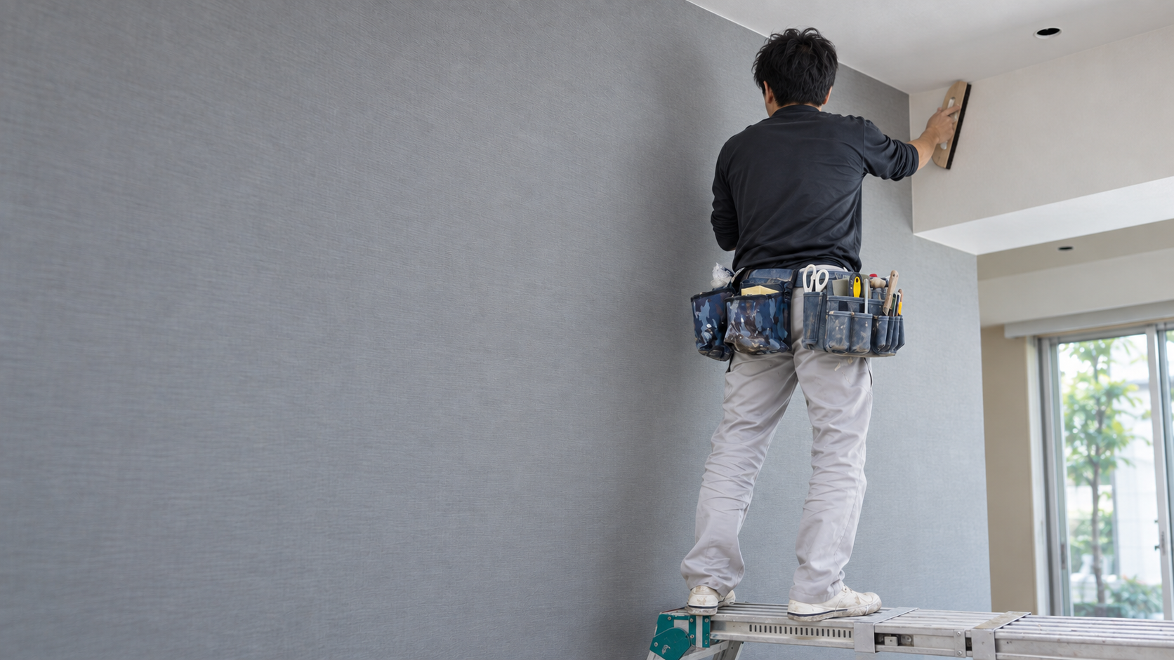 撫で刷毛を使ってクロスを施工する内装職人